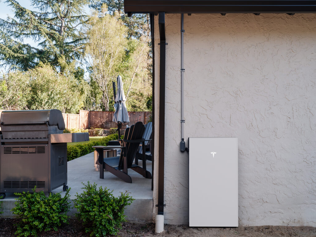Tesla Powerwall 3 installed beside a backyard patio